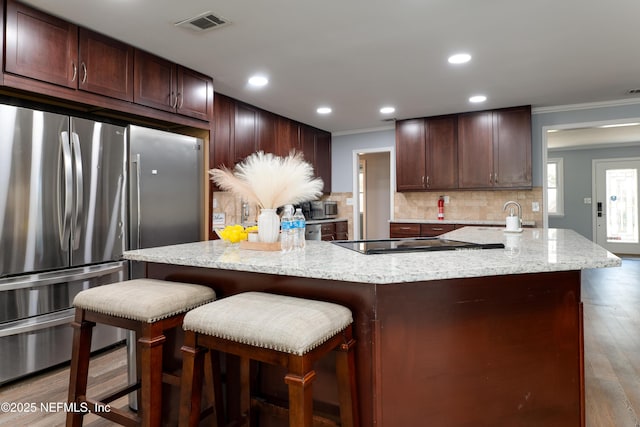 5253 Royce Ave, Jacksonville, FL 32205 - kitchen with freestanding refrigerator, cooktop, ornamental molding, backsplash, and a large island