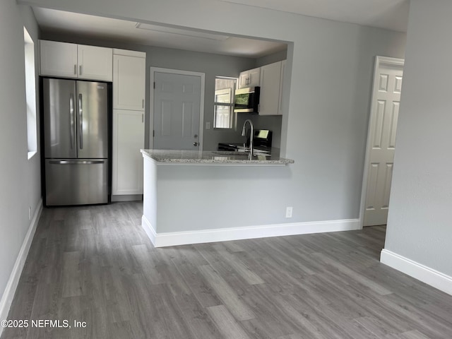 3114 Breve Dr, Jacksonville, FL 32209 - kitchen featuring appliances with stainless steel finishes, light wood-style floors, white cabinetry, and light stone countertops