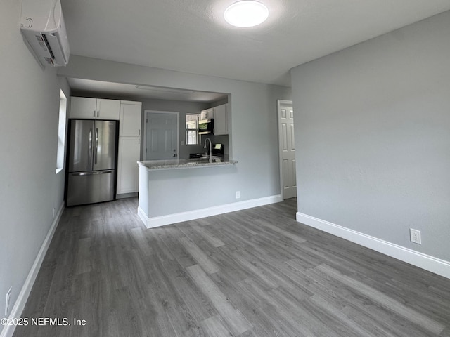 3114 Breve Dr, Jacksonville, FL 32209 - kitchen with stainless steel appliances, white cabinetry, wood finished floors, a sink, and a wall mounted AC