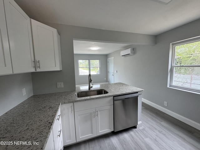 3114 Breve Dr, Jacksonville, FL 32209 - kitchen with dishwasher, a sink, a wall mounted air conditioner, and white cabinetry
