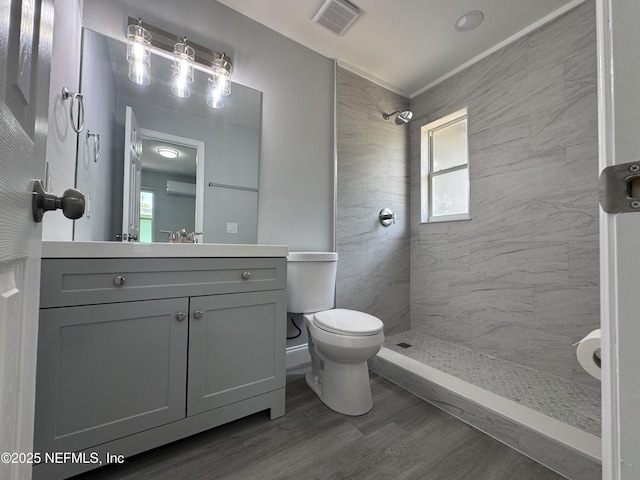 3114 Breve Dr, Jacksonville, FL 32209 - bathroom featuring toilet, a tile shower, vanity, wood finished floors, and plenty of natural light