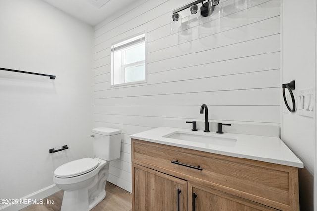 6114 Suwanee Rd, Jacksonville, FL 32217 - half bath with vanity, toilet, wood finished floors, and baseboards