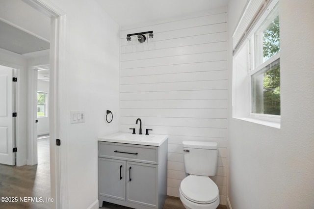 6114 Suwanee Rd, Jacksonville, FL 32217 - half bathroom with vanity, toilet, wood finished floors, and baseboards