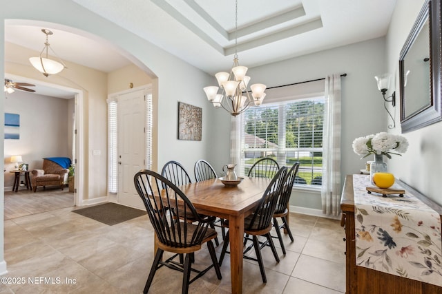 32479 Willow Parke Cir, Fernandina Beach, FL 32034 - dining space with arched walkways, light tile patterned flooring, a chandelier, baseboards, and a ceiling fan