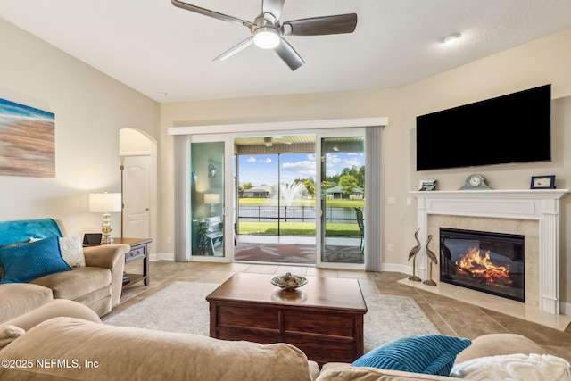 32479 Willow Parke Cir, Fernandina Beach, FL 32034 - tiled living area with a ceiling fan, arched walkways, a fireplace, and baseboards