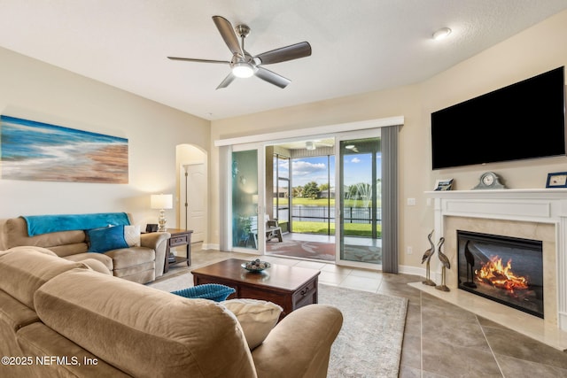 32479 Willow Parke Cir, Fernandina Beach, FL 32034 - living room with ceiling fan, arched walkways, a high end fireplace, light tile patterned floors, and baseboards
