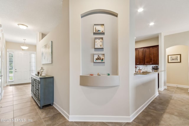 32479 Willow Parke Cir, Fernandina Beach, FL 32034 - hall with baseboards, light tile patterned flooring, arched walkways, and recessed lighting