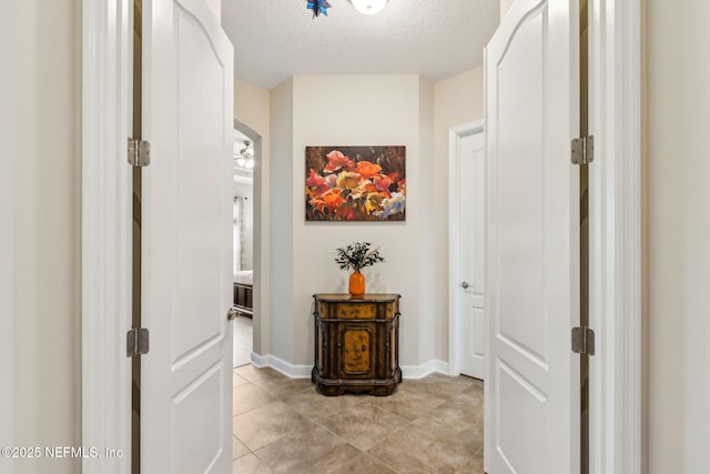 32479 Willow Parke Cir, Fernandina Beach, FL 32034 - hall with a textured ceiling, light tile patterned flooring, and baseboards