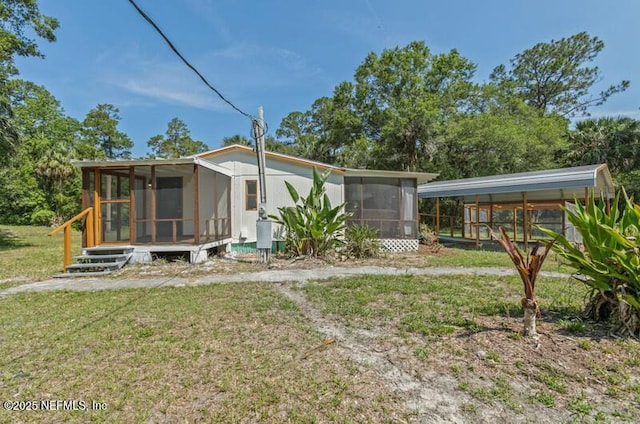 2022 Guava Ln, Bunnell, FL 32110 - rear view of house featuring a sunroom, a yard, and a carport