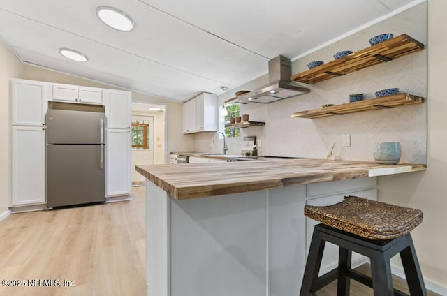 2022 Guava Ln, Bunnell, FL 32110 - kitchen featuring freestanding refrigerator, butcher block countertops, open shelves, range hood, and vaulted ceiling