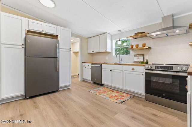 2022 Guava Ln, Bunnell, FL 32110 - kitchen featuring stainless steel appliances, wall chimney range hood, a sink, white cabinets, and lofted ceiling