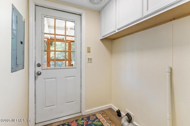 2022 Guava Ln, Bunnell, FL 32110 - laundry room featuring electric panel, cabinet space, baseboards, and wood finished floors