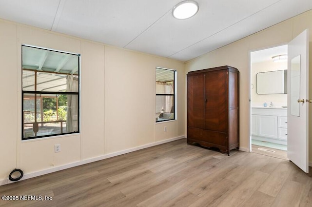 2022 Guava Ln, Bunnell, FL 32110 - unfurnished bedroom featuring light wood-style floors and connected bathroom