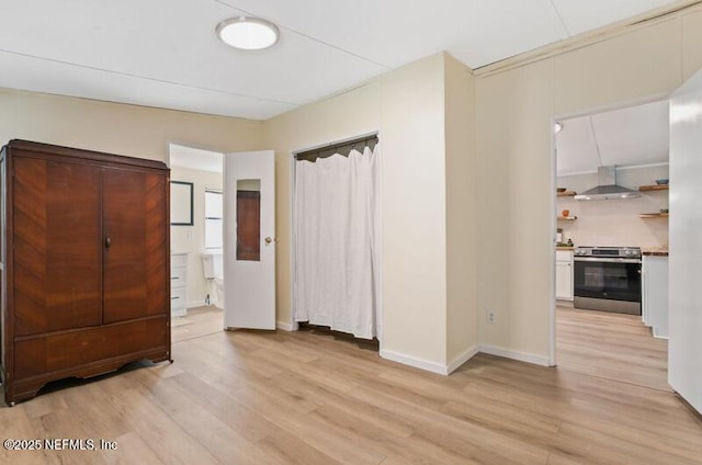 2022 Guava Ln, Bunnell, FL 32110 - unfurnished bedroom with light wood-style flooring, baseboards, and ensuite bathroom