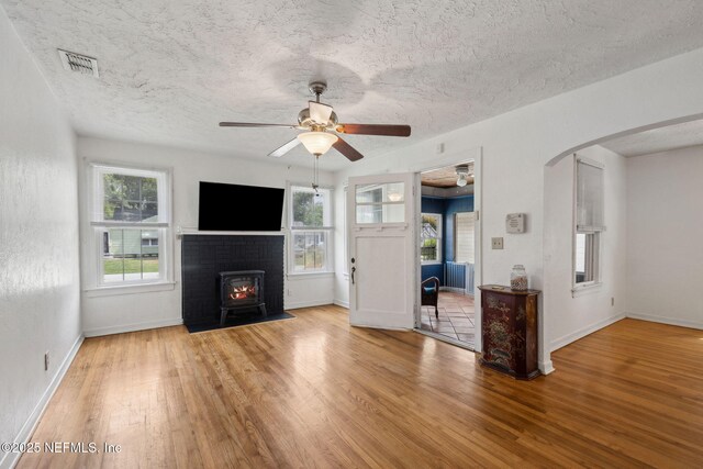 5372 Colonial Ave, Jacksonville, FL 32210 - unfurnished living room featuring wood finished floors, a ceiling fan, baseboards, a textured ceiling, and arched walkways