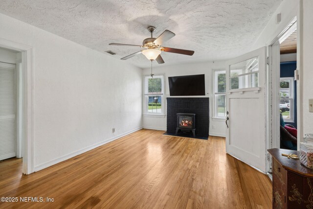 5372 Colonial Ave, Jacksonville, FL 32210 - unfurnished living room featuring light wood-type flooring, ceiling fan, baseboards, and a textured ceiling