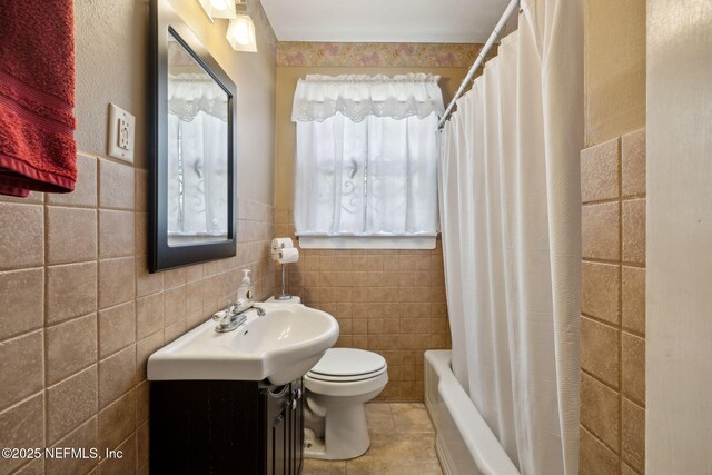 5372 Colonial Ave, Jacksonville, FL 32210 - bathroom featuring toilet, vanity, tile walls, shower / bath combo with shower curtain, and tile patterned flooring
