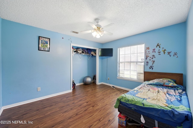 11249 Hartland Rd, Jacksonville, FL 32218 - bedroom with wood finished floors, a textured ceiling, a closet, ceiling fan, and baseboards