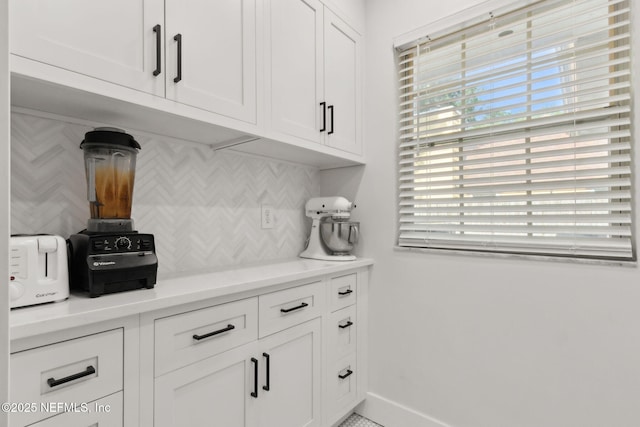 1908 Springbrook Rd, Fernandina Beach, FL 32034 - kitchen with backsplash, white cabinets, light countertops, and baseboards