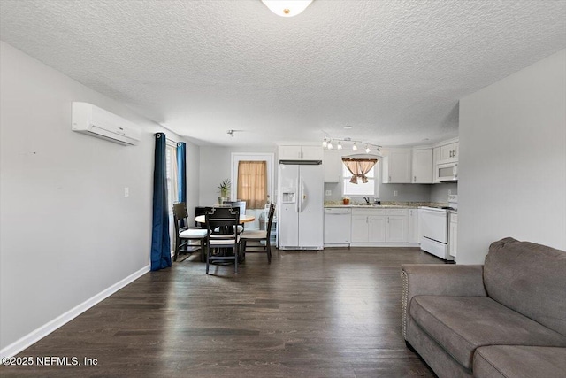 222 Acme St, Jacksonville, FL 32211 - living room featuring a wall unit AC, dark wood-style flooring, a textured ceiling, and baseboards