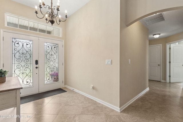79653 Plummers Creek Dr, Yulee, FL 32097 - entrance foyer with arched walkways, french doors, a chandelier, baseboards, and light tile patterned floors