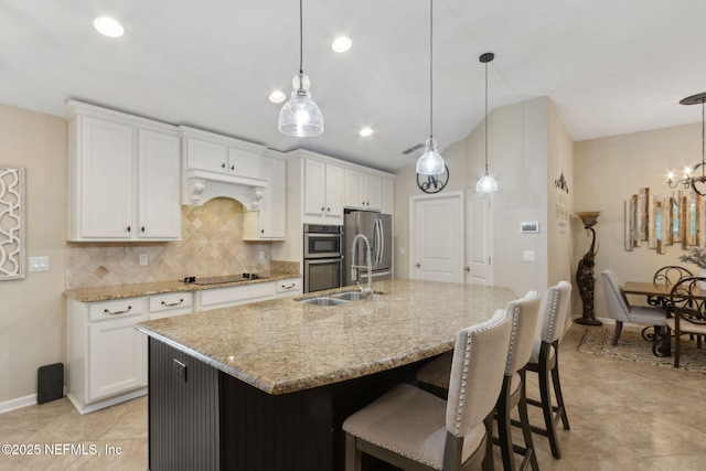 79653 Plummers Creek Dr, Yulee, FL 32097 - kitchen with appliances with stainless steel finishes, decorative backsplash, a sink, a center island with sink, and white cabinets