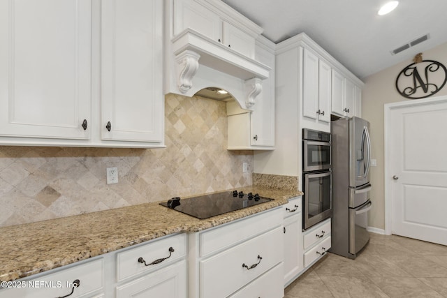 79653 Plummers Creek Dr, Yulee, FL 32097 - kitchen featuring stainless steel appliances, white cabinets, light stone countertops, decorative backsplash, and light tile patterned floors
