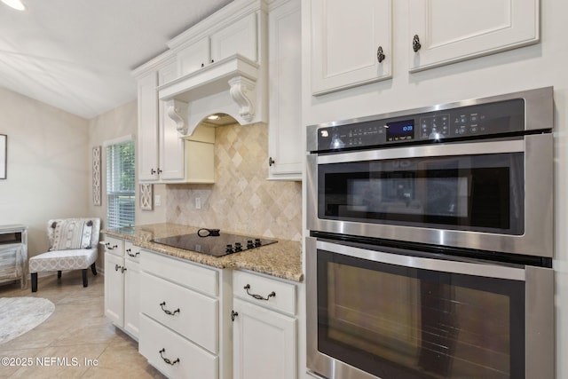79653 Plummers Creek Dr, Yulee, FL 32097 - kitchen featuring double oven, backsplash, white cabinets, and black electric cooktop