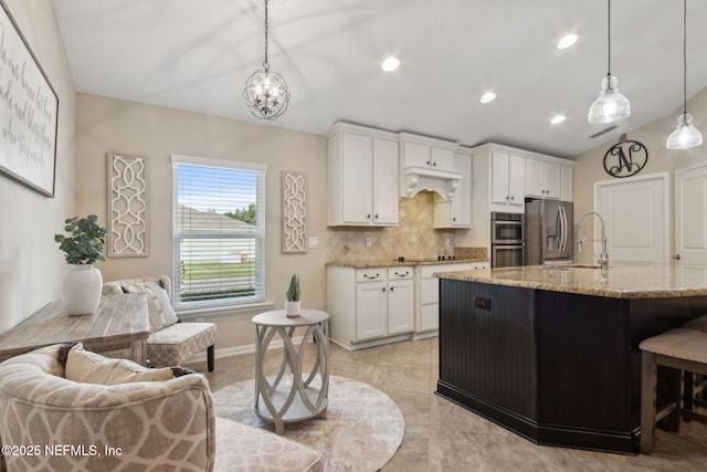 79653 Plummers Creek Dr, Yulee, FL 32097 - kitchen featuring stainless steel appliances, tasteful backsplash, a sink, light stone counters, and lofted ceiling