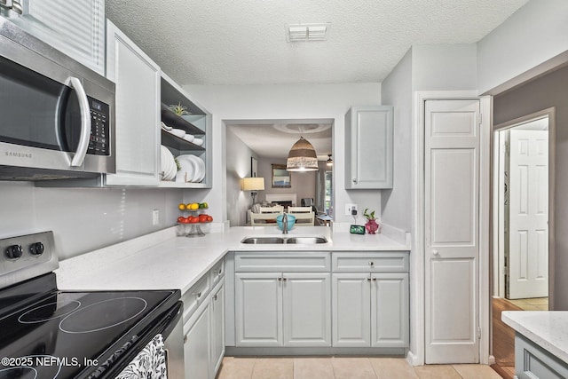 8300 Plaza Gate Ln Unit 1242, Jacksonville, FL 32217 - kitchen featuring appliances with stainless steel finishes, a sink, light countertops, light tile patterned floors, and gray cabinetry