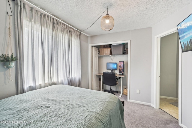 8300 Plaza Gate Ln Unit 1242, Jacksonville, FL 32217 - carpeted bedroom featuring multiple windows, a textured ceiling, an office area, a closet, and baseboards