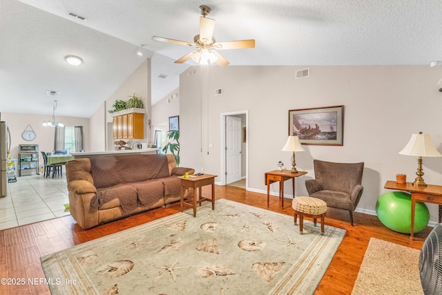 2097 Frogmore Dr, Middleburg, FL 32068 - living area with a ceiling fan, light wood-type flooring, high vaulted ceiling, baseboards, and a textured ceiling