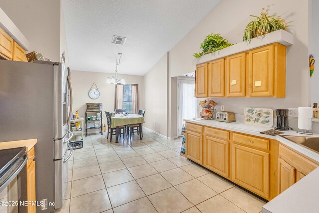 2097 Frogmore Dr, Middleburg, FL 32068 - kitchen with a chandelier, vaulted ceiling, light countertops, appliances with stainless steel finishes, and light tile patterned flooring