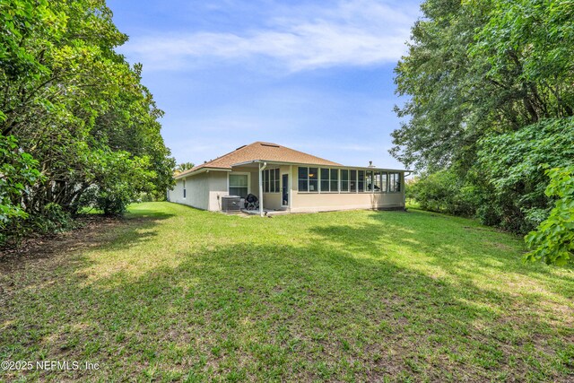 2097 Frogmore Dr, Middleburg, FL 32068 - rear view of property with central AC unit, a lawn, a sunroom, and stucco siding
