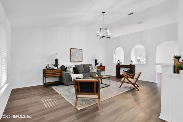3409 Steelgate Ct, Middleburg, FL 32068 - living room featuring a chandelier, wood finished floors, lofted ceiling, baseboards, and arched walkways
