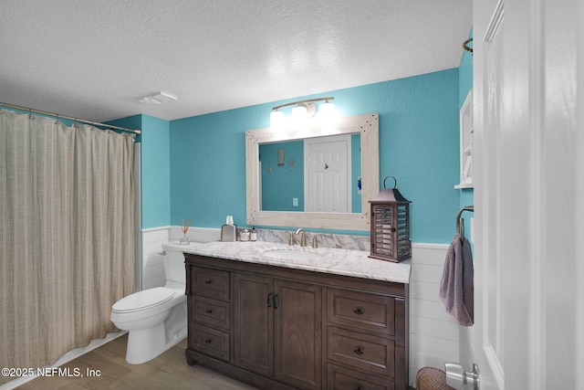 430 Timberwalk Ct Unit 1023, Ponte Vedra Beach, FL 32082 - bathroom featuring wainscoting, a textured ceiling, wood finished floors, toilet, and vanity