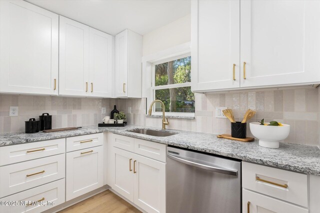 1129 Sebago Ave N, Jacksonville, FL 32233 - kitchen featuring stainless steel dishwasher, a sink, and white cabinets