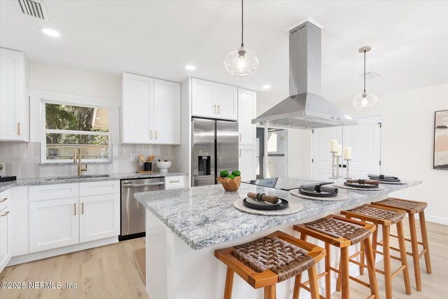 1129 Sebago Ave N, Jacksonville, FL 32233 - kitchen with appliances with stainless steel finishes, a sink, island range hood, light wood-style floors, and recessed lighting