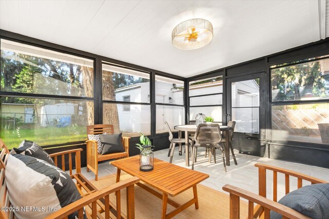 1129 Sebago Ave N, Jacksonville, FL 32233 - sunroom featuring a wall of windows, outdoor dining space, tile patterned floors, and outdoor lounge area