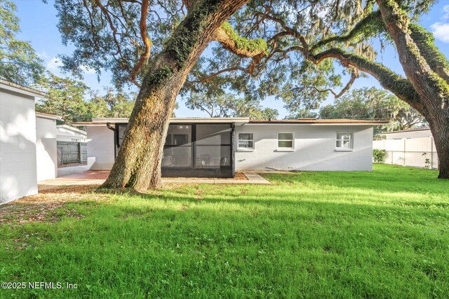 1129 Sebago Ave N, Jacksonville, FL 32233 - rear view of property featuring a sunroom and concrete block siding