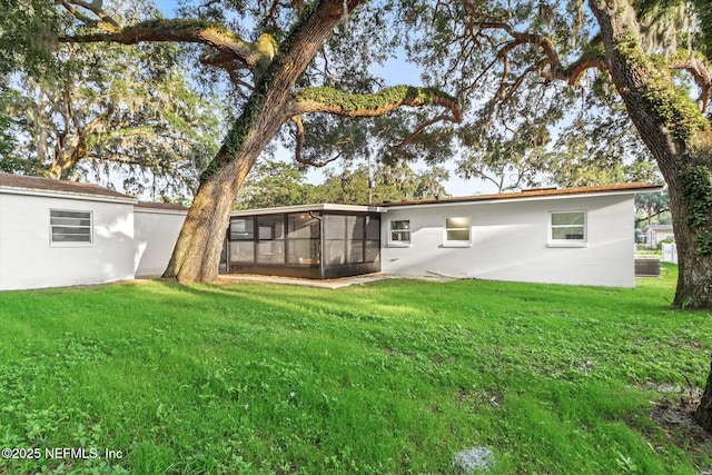 1129 Sebago Ave N, Jacksonville, FL 32233 - back of property with a sunroom, a yard, and central AC unit