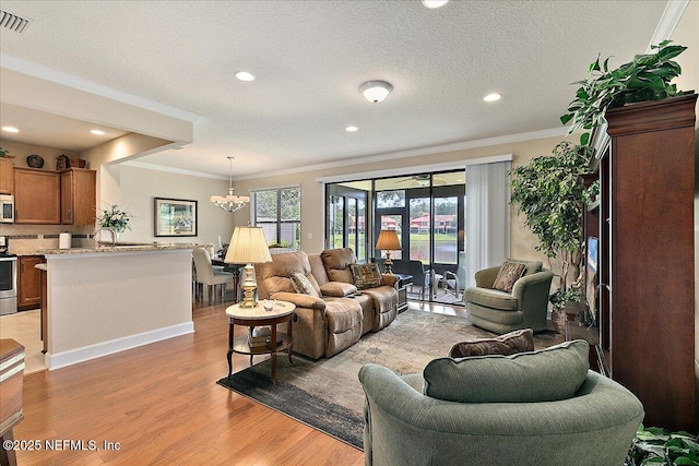 13409 Isla Vista Dr, Jacksonville, FL 32224 - living area featuring ornamental molding, light wood-style floors, a chandelier, recessed lighting, and baseboards