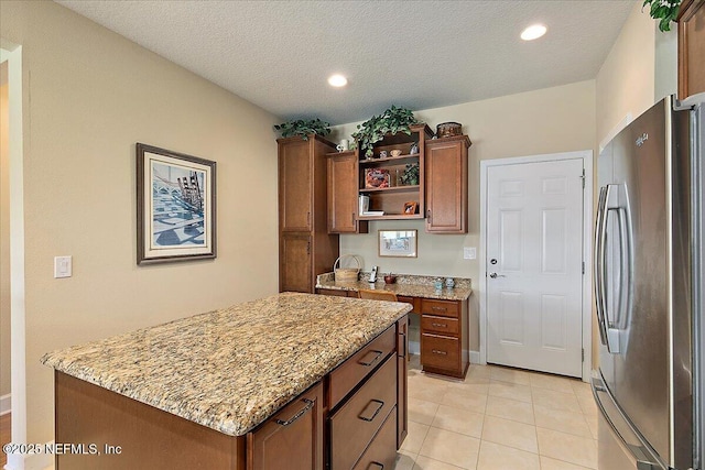 13409 Isla Vista Dr, Jacksonville, FL 32224 - kitchen with freestanding refrigerator, open shelves, light stone countertops, brown cabinets, and recessed lighting