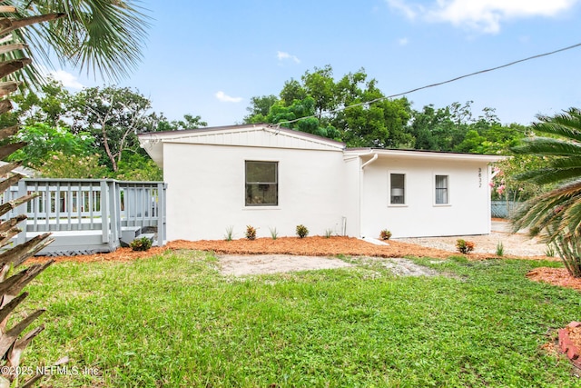 3832 Bunnell Dr, Jacksonville, FL 32246 - view of side of home featuring stucco siding and a lawn