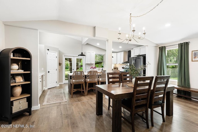86290 Weldon Ave, Yulee, FL 32097 - dining space with vaulted ceiling, a chandelier, healthy amount of natural light, and wood finished floors