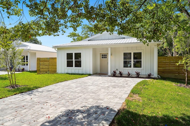 771 W 4th St, Saint Augustine, FL 32084 - view of front facade with board and batten siding, metal roof, and covered porch