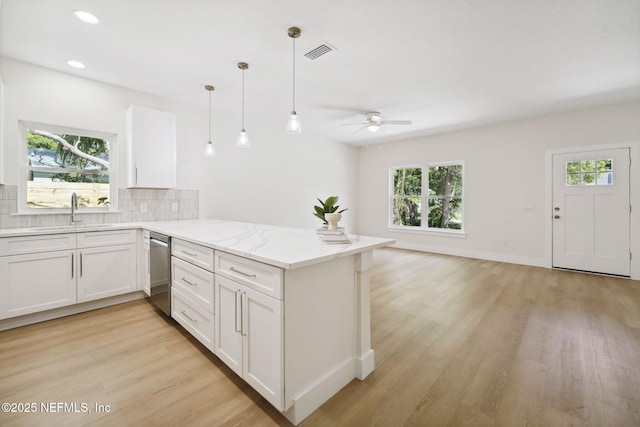 771 W 4th St, Saint Augustine, FL 32084 - kitchen featuring stainless steel dishwasher, a sink, a peninsula, ceiling fan, and light wood-style flooring