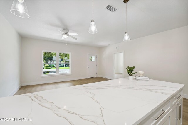 771 W 4th St, Saint Augustine, FL 32084 - kitchen with light wood-type flooring, light stone counters, a ceiling fan, and hanging light fixtures