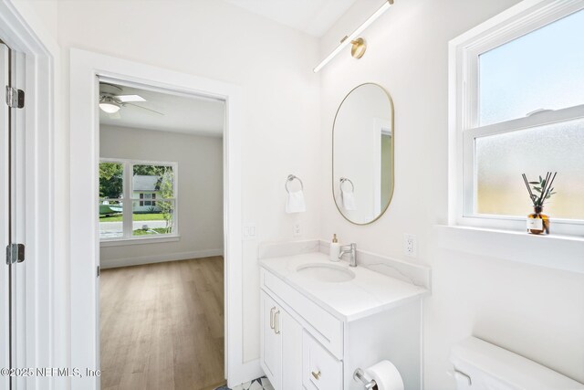 771 W 4th St, Saint Augustine, FL 32084 - bathroom featuring vanity, toilet, wood finished floors, ceiling fan, and baseboards