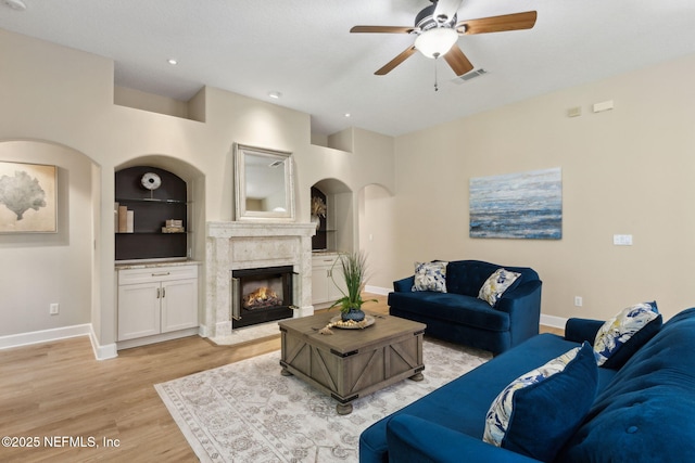 86569 N Hampton Club Way, Fernandina Beach, FL 32034 - living room with ceiling fan, baseboards, light wood-type flooring, built in features, and a premium fireplace